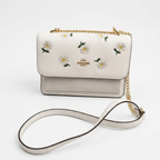 Coach Klare crossbody bag with daisy embroidery in white smooth leather with a gold-tone chain strap