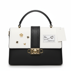 black and white top-handle satchel bag with a shoulder strap and gold-tone hardware