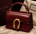Maroon Gucci Dionysus top handle bag with a silver-tone tiger head closure.