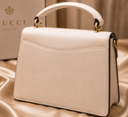 white Gucci Dionysus top handle bag with a silver-tone tiger head closure.
