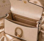 white Gucci Dionysus top handle bag with a silver-tone tiger head closure.