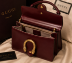Maroon Gucci Dionysus top handle bag with a silver-tone tiger head closure.