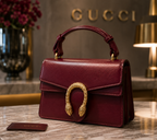 Maroon Gucci Dionysus top handle bag with a silver-tone tiger head closure.