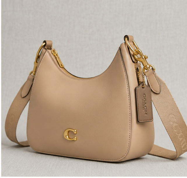 Coach Small Jonie 22 half-moon leather shoulder bag in a neutral color.