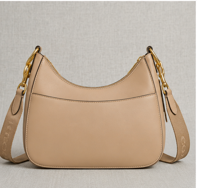 Coach Small Jonie 22 half-moon leather shoulder bag in a neutral color.