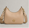 Coach Small Jonie 22 half-moon leather shoulder bag in a neutral color.