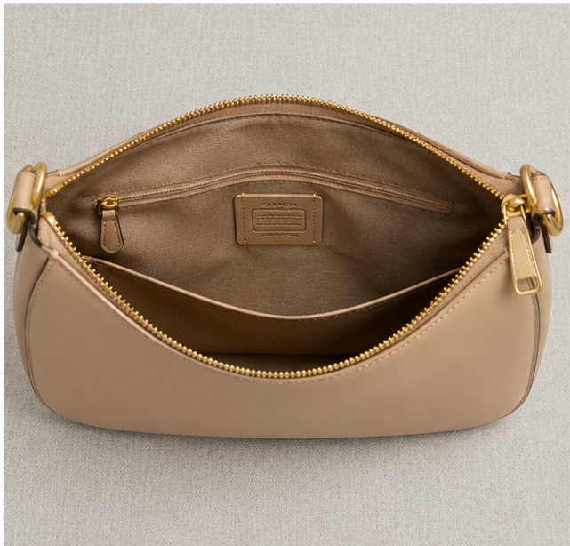 Coach Small Jonie 22 half-moon leather shoulder bag in a neutral color.